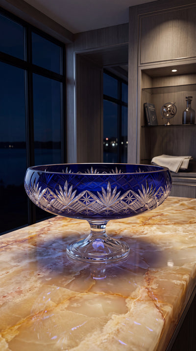 Midnight Sapphire Coronet pedestal bowl on an amber marble counter at night