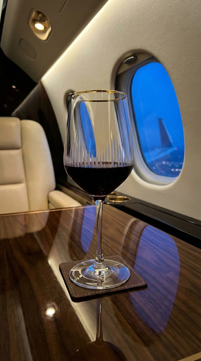 Ascend Bordeaux Wine Glass with red liquid on a table in an aircraft cabin