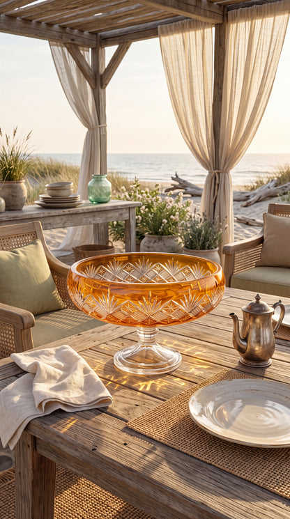 Sunlit Amber Coronet Pedestal Bowl on a rustic seaside table beneath a pergola.