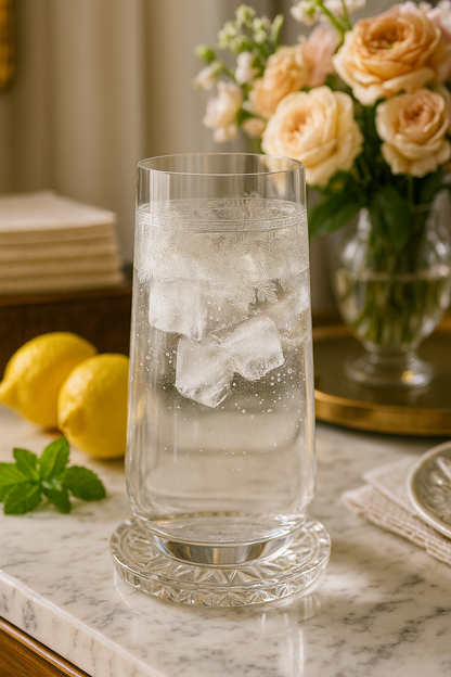 Filigrae Highball with an iced clear drink beside lemons, mint and cream roses.
