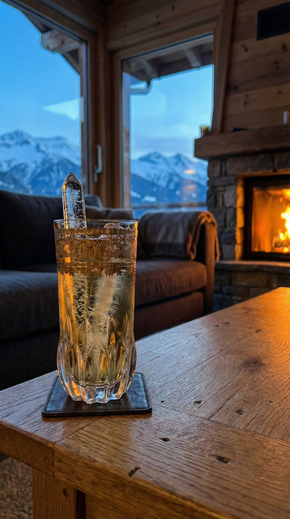 Majora Highball with ice on a chalet table beside a fireplace and snowy mountain view