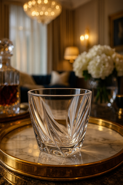 Calyx Tumbler on a round gold tray before white flowers in a chandelier-lit sitting room.
