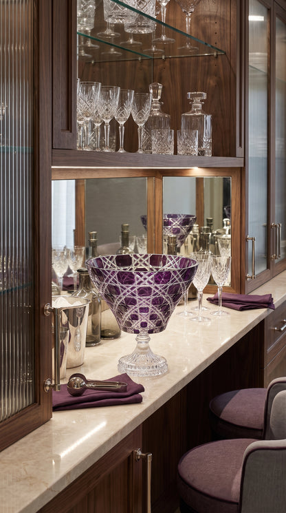 Verdura Regal Violet trumpet bowl displayed on a sideboard beneath a glass cabinet