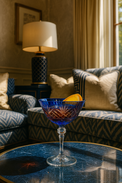 Midnight Sapphire Veyra Coupe on a blue glass coffee table in a patterned lounge.