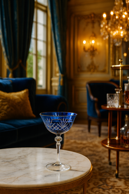 Midnight Sapphire Veyra Coupe on a round marble table in an ornate blue sitting room.